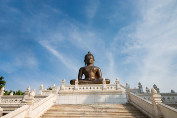 Buddha statue in temple with blue sky background.