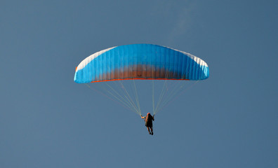 paraglider flight through the blue sky