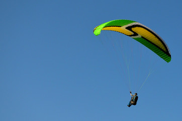 paraglider flight through the blue sky