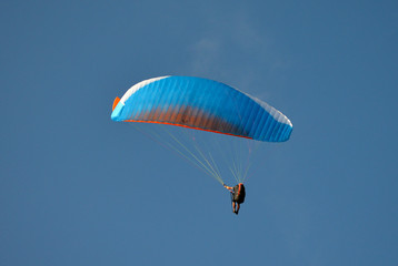 paraglider flight through the blue sky