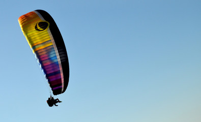 paraglider flight through the blue sky
