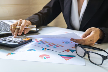 Businesswoman working on Desk office with marketing graph statistics analysis