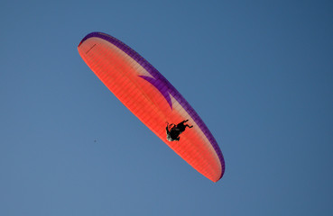 paraglider flight through the blue sky