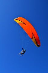 paraglider flight through the blue sky