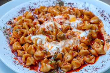 Traditional delicious Turkish foods; Kayseri Manti. Food concept photo.