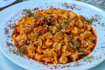 Traditional delicious Turkish foods; Kayseri Manti. Food concept photo.
