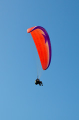 paraglider flight through the blue sky