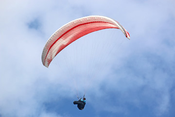 Paraglider flying red wing