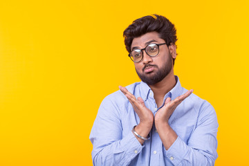 Young doubting mixed race male student with glasses and formal clothes posing on a yellow background with copy space