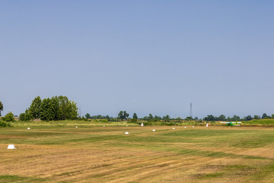 The field with runway and the small aircraft, grass field runway - Image