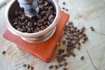  Manual coffee grinder on a wooden, light background with coffee beans