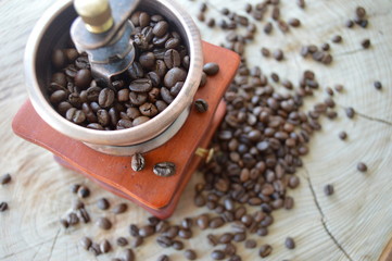  Manual coffee grinder on a wooden, light background with coffee beans