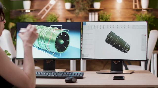 Creative designer works in professional 3D software application. She designs new turbine prototypes. Creative media agency office.