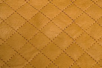 Quilted yellow with gold leather texture or background, closeup