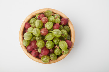 Gooseberries fruits on white background. Bowls with gooseberries isolated on white background. Red and green gooseberries in a bowl with copy space for text. Ripe gooseberry close-up.  K