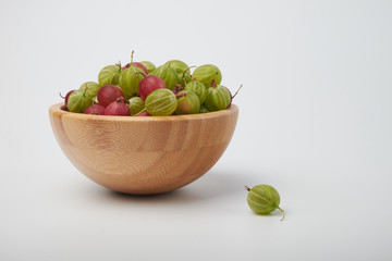 Gooseberries fruits on white background. Bowls with gooseberries isolated on white background. Red and green gooseberries in a bowl with copy space for text. Ripe gooseberry close-up.  K