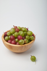 Gooseberries fruits on white background. Bowls with gooseberries isolated on white background. Red and green gooseberries in a bowl with copy space for text. Ripe gooseberry close-up.  K