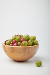 Gooseberries fruits on white background. Bowls with gooseberries isolated on white background. Red and green gooseberries in a bowl with copy space for text. Ripe gooseberry close-up.  K