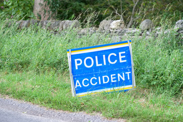 Police accident sign at road crash in rural countryside blind bend