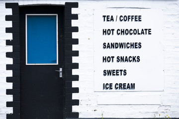 Tea coffee room cafe serving sandwiches hot snacks sweets and ice cream sign on white wall