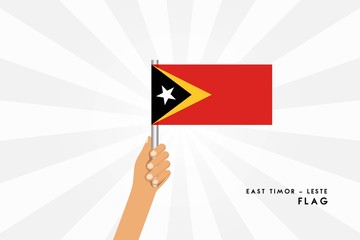 Vector cartoon illustration of human hands hold East Timor flag. Isolated object on white background.