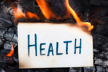 Burning paper with word health. Concept of ill health. Dangerous incurable disease
