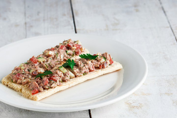 salad with tuna tomato cucumber boiled egg on  crisp bread open sandwiches on plate on white table copy space