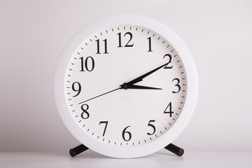 Round clock close up. Watch with a large round dial on a light background.