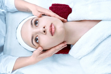 View from above of woman relaxing during massage of face