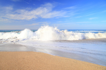waves on the water of a sandy summer beach