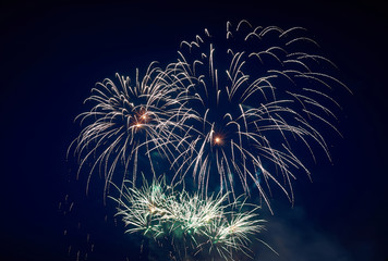 Big and small, beautiful sparkling volleys of festive fireworks, green, in the night sky