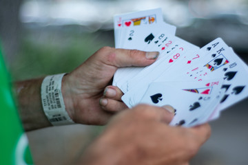A street magician holding a deck of cards