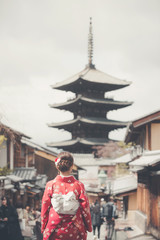 Asian woman wearing traditional Japanese kimono walking in the old town of Kyoto, Japan
