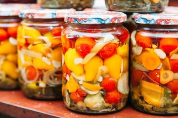 pickled tomatoes and zucchini in a glass jar