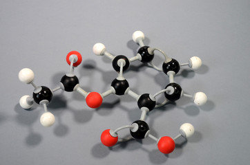 Molecule model of acetylsalicylic acid HC9H7O4 (ASA). Red is oxygen, black is carbon, and white is hydrogen.