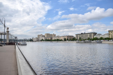 Obraz premium Moscow, Russia - May 13, 2019: The view from the Krymskaya embankment to the Moskva river and Frunzenskaya embankment against the blue sky with clouds