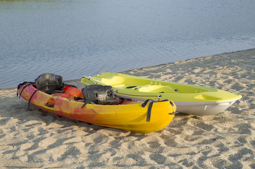 Two types of kayak two-seat sit-on-top  on the sandy bank of the river Veleka, Bulgaria