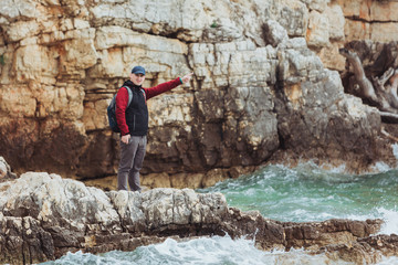 sea travel concept man at cliff with storming windy weather