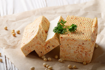 Soy Bean curd tofu on parchment paper with greens Non-dairy alternative substitute for cheese