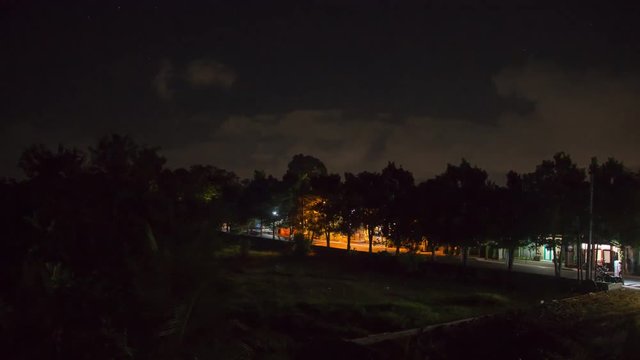 Time Lapse of Street and Stars at Night With Light Trails From Moving Cars on a Small Lane in Ubud, Bali