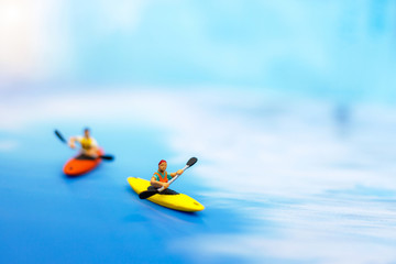 Miniature people on board of sea canoo. Summer concept.