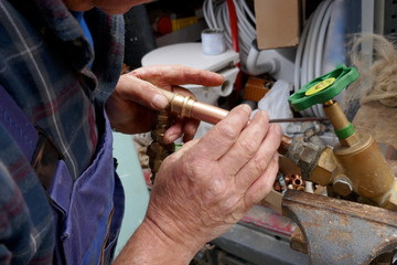 Plumber during the preparation work to install an outdoor faucet.