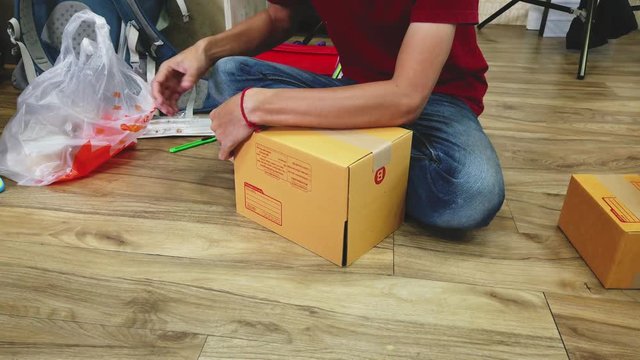 Business owner work at home wrapping parcel box, Alpha generation life style. Businessman entrepreneurial successful. Sales Online Parcel delivery. New generation life style of young entrepreneur.