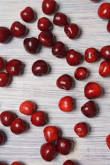 Red sweet cherry scattered on a white wooden table