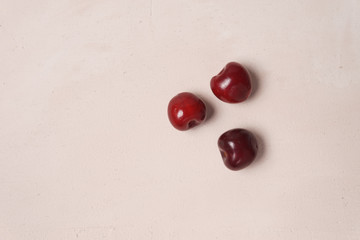 Red sweet cherry scattered on cream background