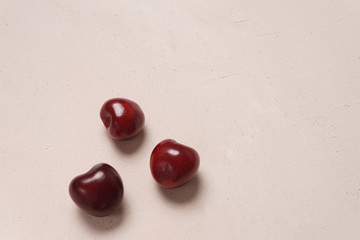 Red sweet cherry scattered on cream background