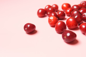 Red sweet cherry scattered on a pink background