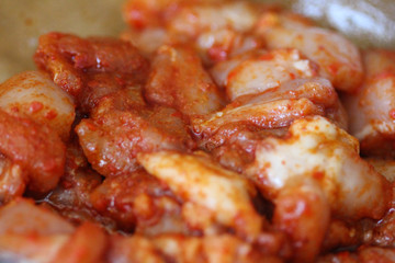 marinated chicken indian tandoori seasoning in a bowl, on wooden background, in the kitchen