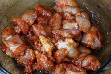 marinated chicken indian tandoori seasoning in a bowl, on wooden background, in the kitchen
