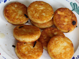 fresh baked hommade potato pancakes, also named rosti, hash browns, kartoffelpuffer, latkes, draniki - on white plate on wooden background.